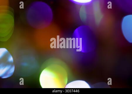 A blurry image of colorful lights with a purple and green circle in the middle. The image has a dreamy and whimsical mood Stock Photo