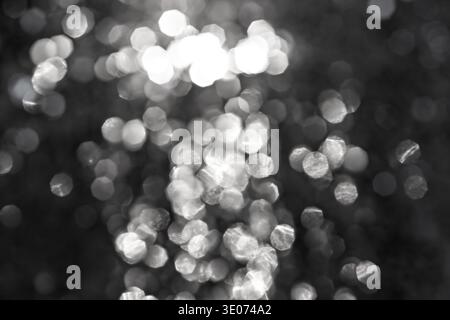 Defocused black and white light spots forming an abstract bokeh background, ideal for texture, overlays, modern design, and artistic compositions. Stock Photo