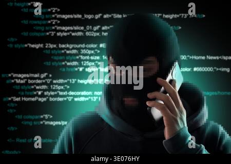 Criminal in mask talking on phone against programming code. Cyber security Stock Photo