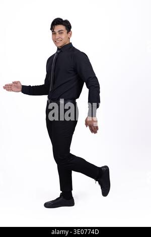 Man in black formal attire pointing to the side Stock Photo