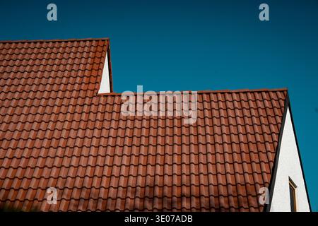 Red Clay Tiled Roof Against Blue Sky: Minimal Architectural Detail Of Traditional Bavarian House Stock Photo