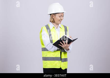 Female engineer in hard hat and vest holding tablet Stock Photo