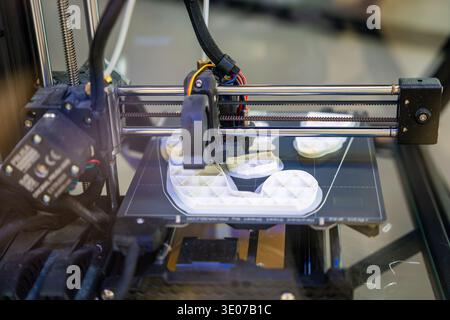 3D printer creating plastic objects with precision and speed. The concept represents modern manufacturing, rapid prototyping, and the future of custom Stock Photo