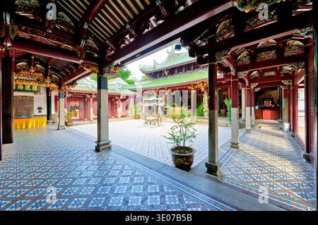 Visitors pay respect at colorful altars in Thian Hock Keng Temple in Singapore. The temple space is full of activity and tradition. Stock Photo