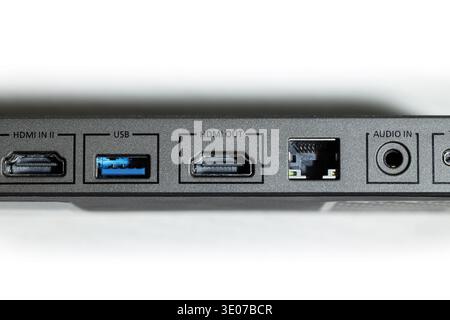 Detailed view of a modern electronic device's back panel, featuring labeled ports like HDMI, USB, Ethernet, and audio jacks for versatile connections Stock Photo