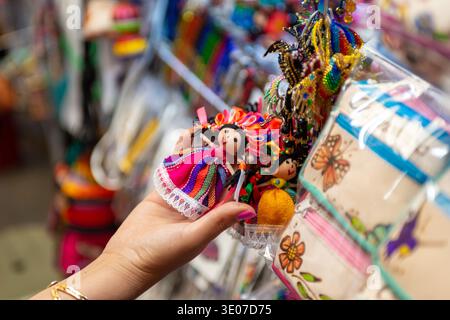 Woman Hand Holding Traditional Mexican Rag Doll Souvenir at Market Stock Photo