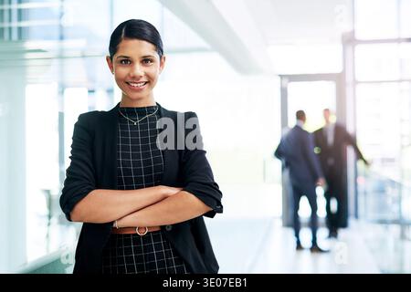 Business, woman and smile with arms crossed at firm for legal internship, career growth and about us. Staff, law intern and portrait in office for Stock Photo