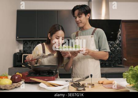 Asian Young couple cooking in the kitchen at home Stock Photo