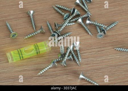 Screws and dowels on a wooden table, closeup of photo Stock Photo