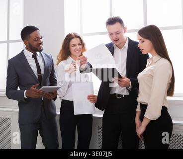 Surprised business team looking at documents in office Stock Photo
