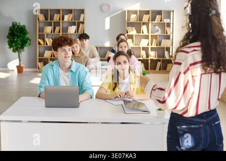 Attentive teen students listening to teacher in bright modern classroom setting Stock Photo