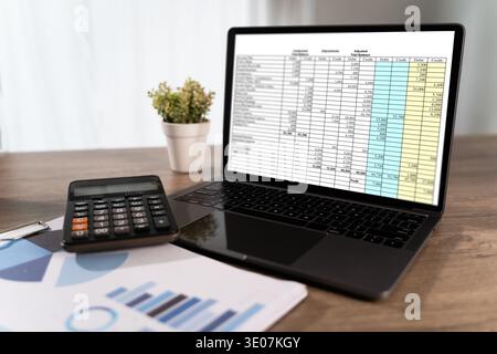 Financial report on laptop screen with calculator and business chart on desk, accounting and budgeting concept, business analysis, audit, tax planning Stock Photo