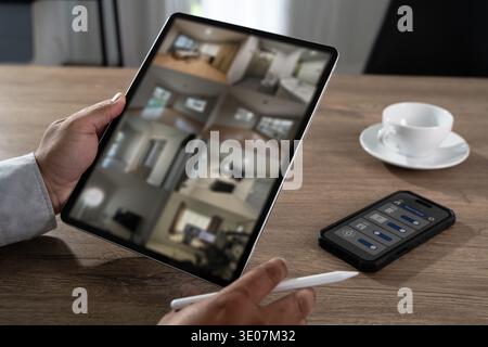SmartHome Security Monitoring Control Interface Technology Person using tablet for smarthome security monitoring and surveillance control Smart home t Stock Photo
