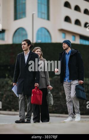Business associates walking and talking outside a modern office building on a cool day Stock Photo