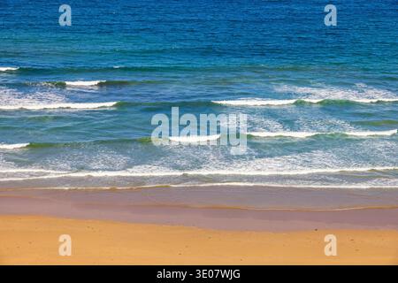 Breaking sea waves at a sand beach Stock Photo