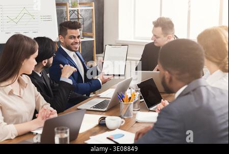 Businessman showing annual report to his colleagues Stock Photo