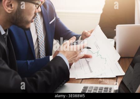 Colleagues discussing company balance with graphs Stock Photo