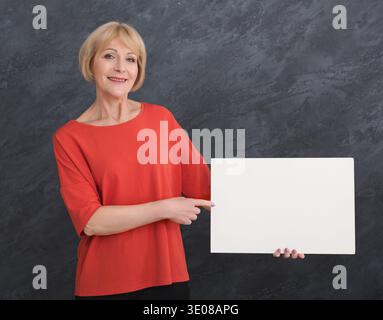 Happy middle aged woman with blank white paper Stock Photo