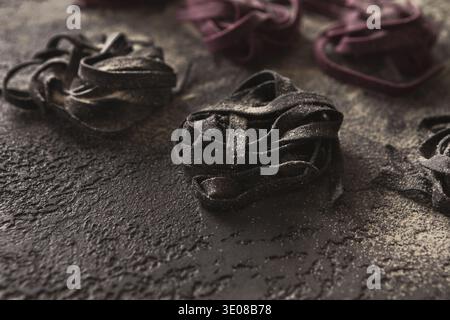 Colorful tagliatelli nests on black background Stock Photo