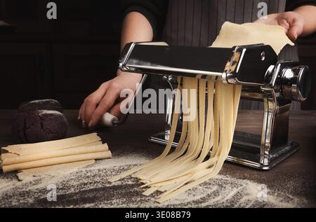 Preparing homemade fettuccine on pasta machine Stock Photo