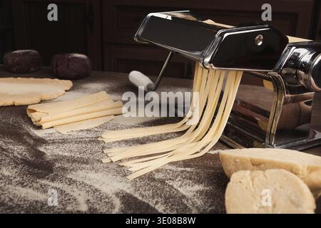 Preparing homemade fettuccine on pasta machine Stock Photo
