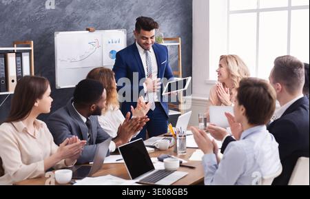 Business people applauding for colleague after presentation Stock Photo