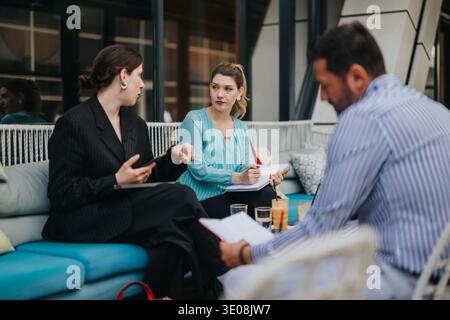 Business colleagues having a collaborative meeting and taking notes during an outdoor office discussion Stock Photo