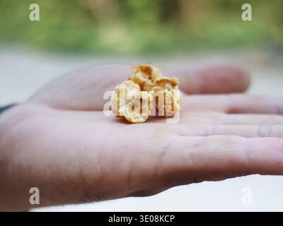 Caramel-coated popcorn placed on a person's palm. Stock Photo