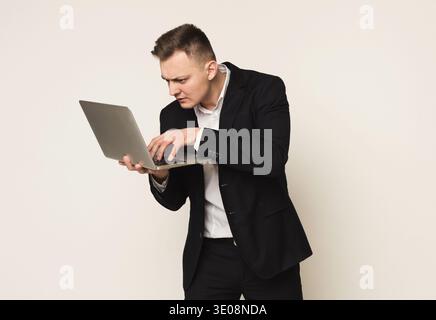 Disappointed caucasian businessman using laptop Stock Photo