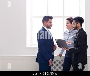 Business colleagues having conversation in office near window Stock Photo