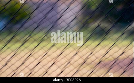 color abstract motion blur of chain link fence with diamond shapes shot at slow shutter speed using ICM intentional camera movement effect Stock Photo