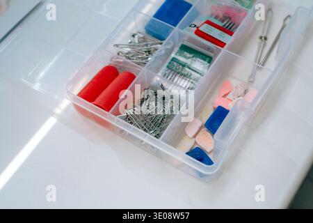 Sewing notions box with pins needles and chalk pieces in natural light Stock Photo