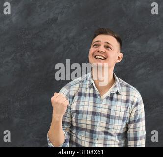 Satisfied young man celebrating success Stock Photo