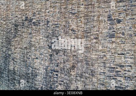 A detailed close-up of a weathered brick wall, showcasing various textures and unique patterns. This image captures the rustic charm of aged architect Stock Photo