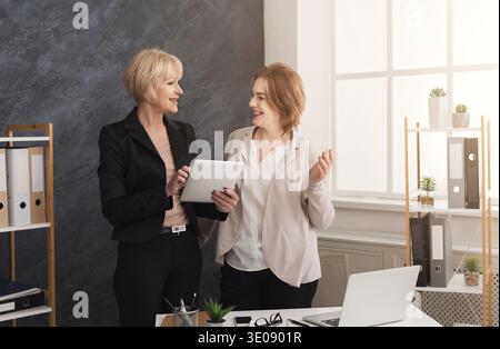 Two business women colleagues working together on tablet Stock Photo