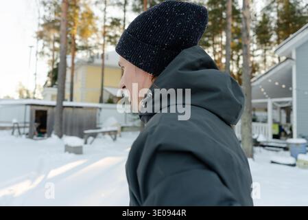 Back view of a middle-aged man at the end of his warmup outdoors. Guy prepares to run in cold weather, showing his athletic build. Stock Photo