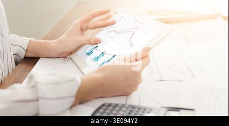 Woman looking at graph on digital tablet Stock Photo