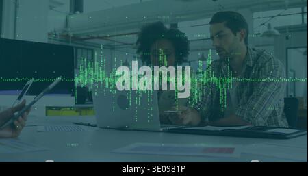 Reviewing team in business attire using laptop sticker, charts and tablet at office, green overlay Stock Photo