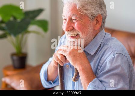 Portrait of happy mature 80s man sit on couch at home look at camera posing relaxing on weekend, smiling positive senior 70s grandfather rest on sofa Stock Photo