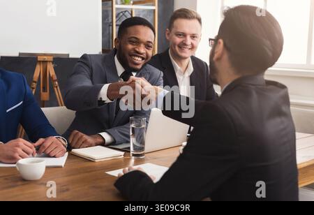 Business handshake at multiethnic office meeting Stock Photo