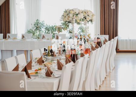 Riga, Latvia - June 12, 2023:Elegant banquet table prepared for a wedding reception or formal celebration, featuring floral centerpieces, drinks, and Stock Photo