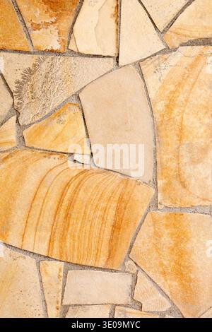 Wall lined with light yellow porphyry stones Stock Photo