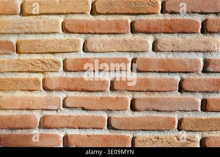Modern red brick wall background with cracks in concrete Stock Photo