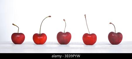 Row of freshly cherries on white background. Stock Photo