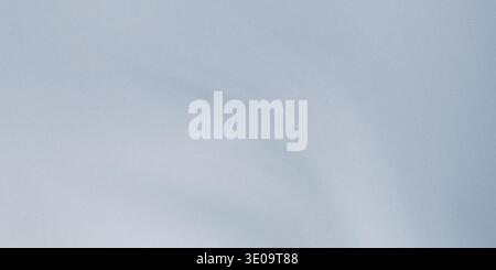 A close-up view of a blue grey paper texture with a subtle gradient effect, showing its smooth surface and gentle color transition Stock Photo