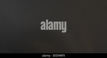 A black gradient background with a dark shadow effect, transitioning from dark to black with a subtle texture Stock Photo