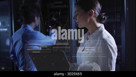 Operating woman IT engineer in white shirt using holographic HUD at data center with server racks Stock Photo
