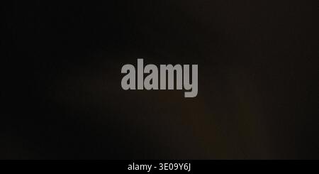This image presents a dark gradient shadow on a black textured background. The shadow has a strong contrast, creating a dramatic effect. The backgroun Stock Photo