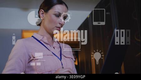 Inspecting IT tech in pink shirt and blue lanyard using rack screen with server-racks and icons Stock Photo