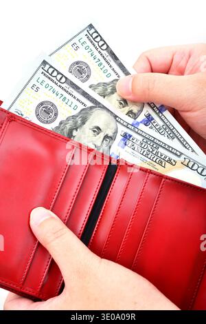 Red purse with US dollars in the hands on a white background Stock Photo